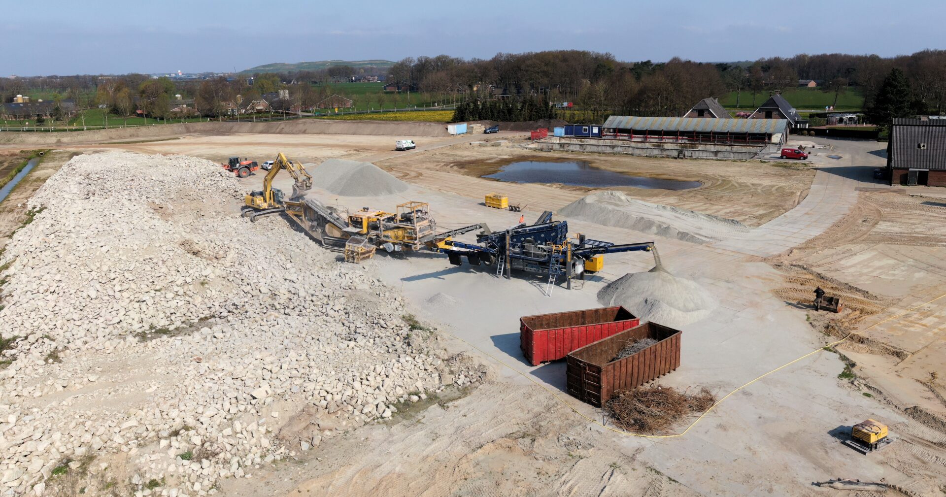 Machines verwerken fundamenten oude fabriek Bosch Beton in Kootwijkerbroek tot granulaat